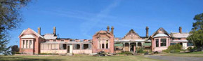 Photo by Ross Thompson of the Old Bega Hospital after the 2004 fire, missing most of its roof and no glass in the windows